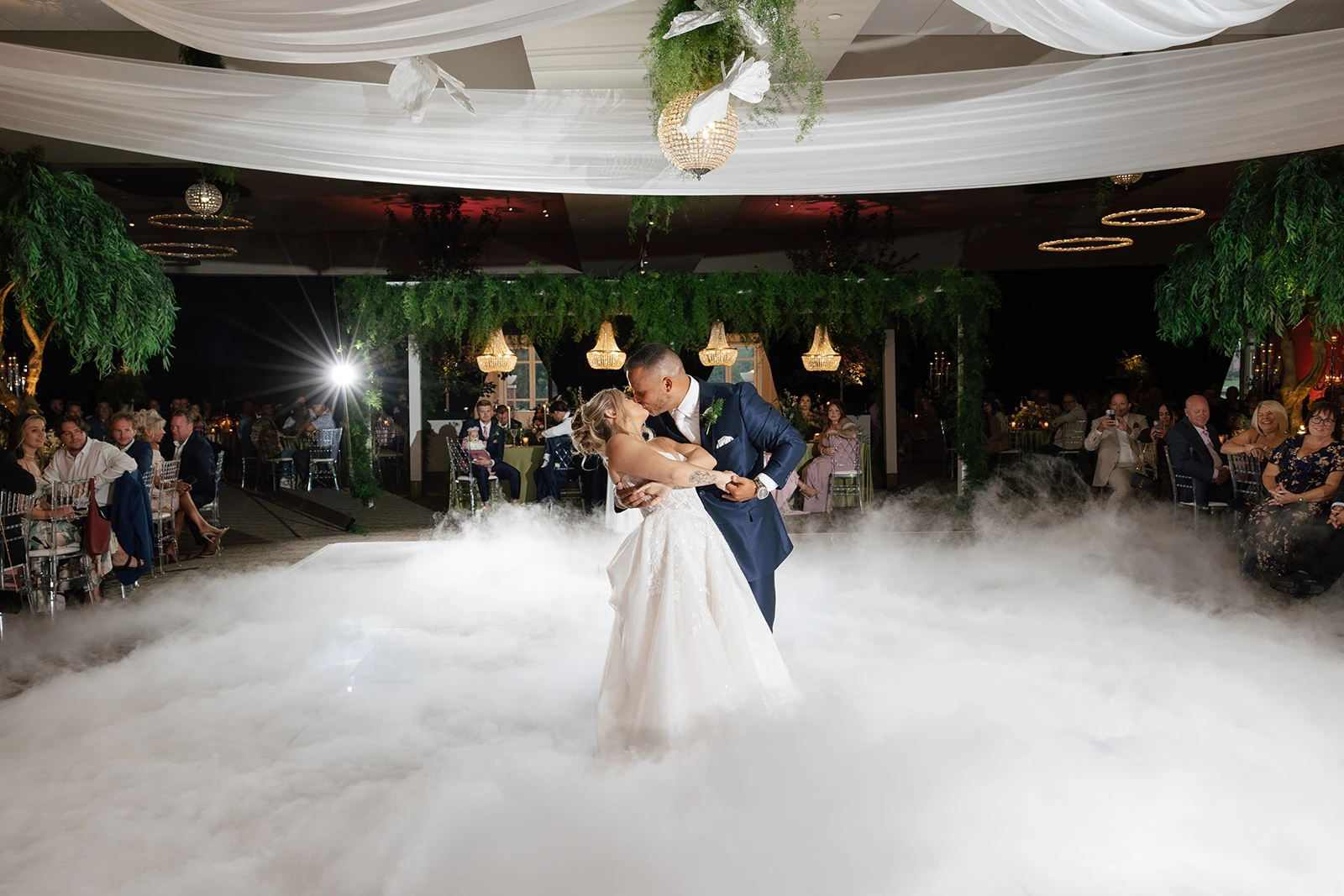 Wedding couple sharing a first-dance dip amid low-lying fog on the all-white floor at Waypoint 4180