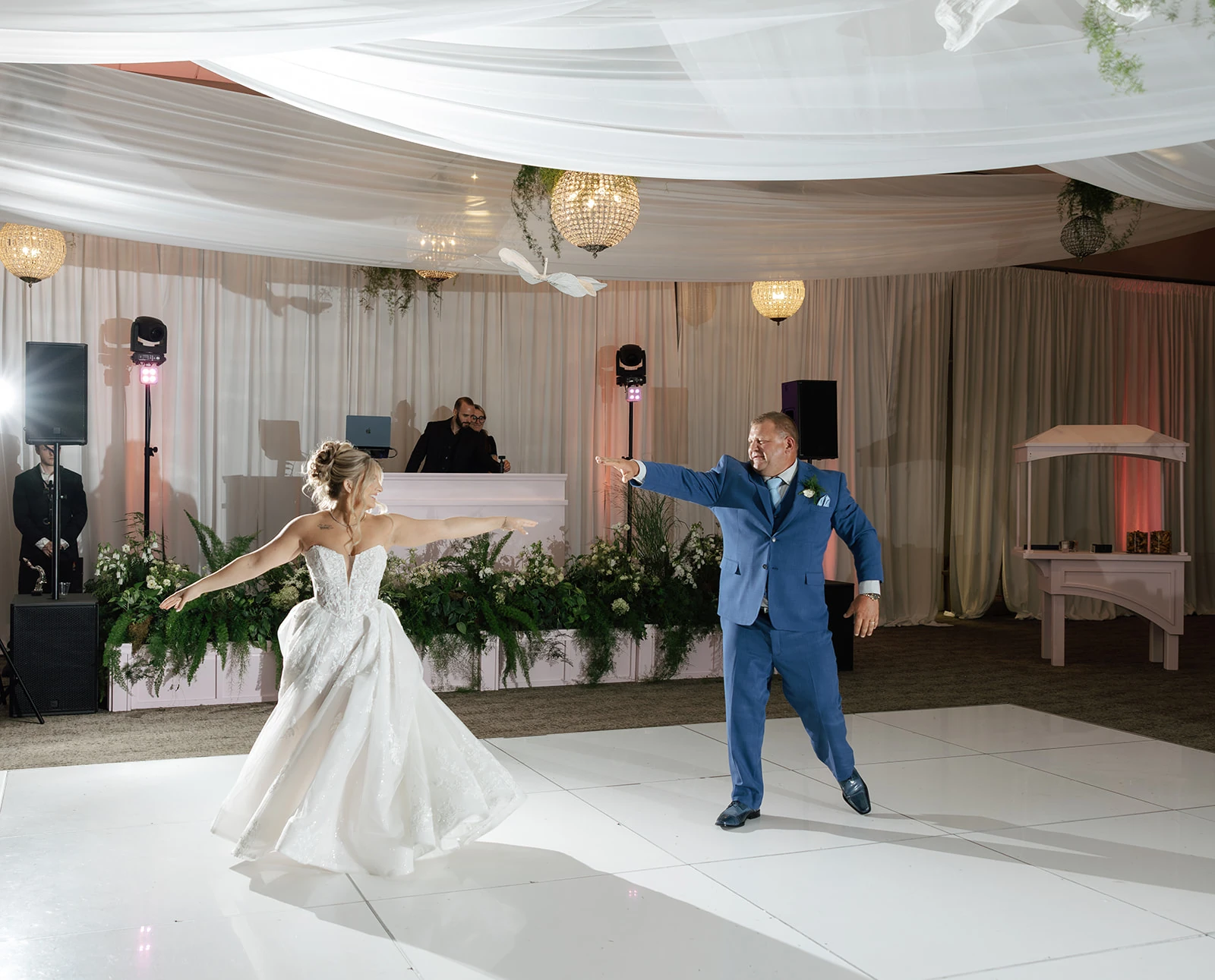 A bride and wedding guest dancing on a glossy all-white paneled floor at Waypoint 4180