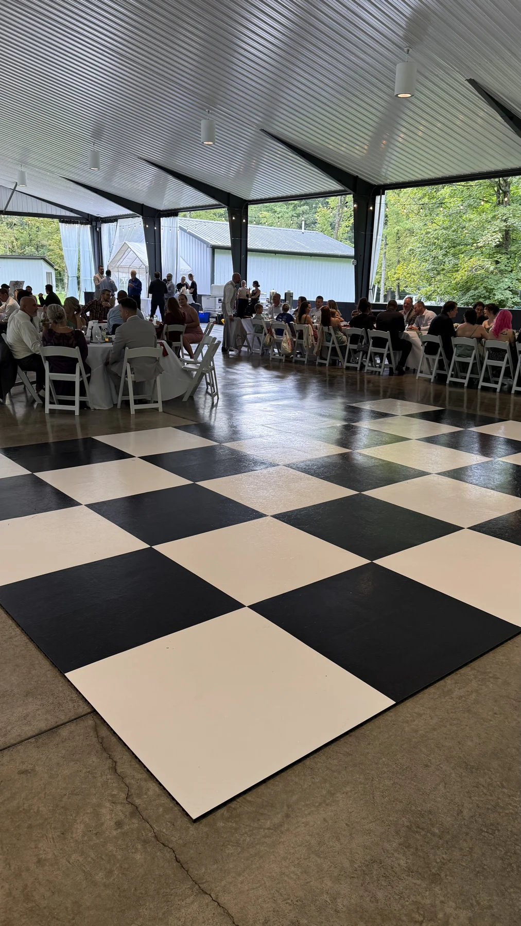 Real large checkerboard floor with wedding guests and tables in a pavilion